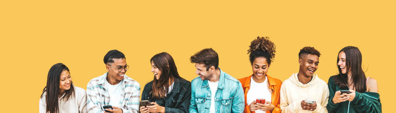 group of students looking at phones and laughing together